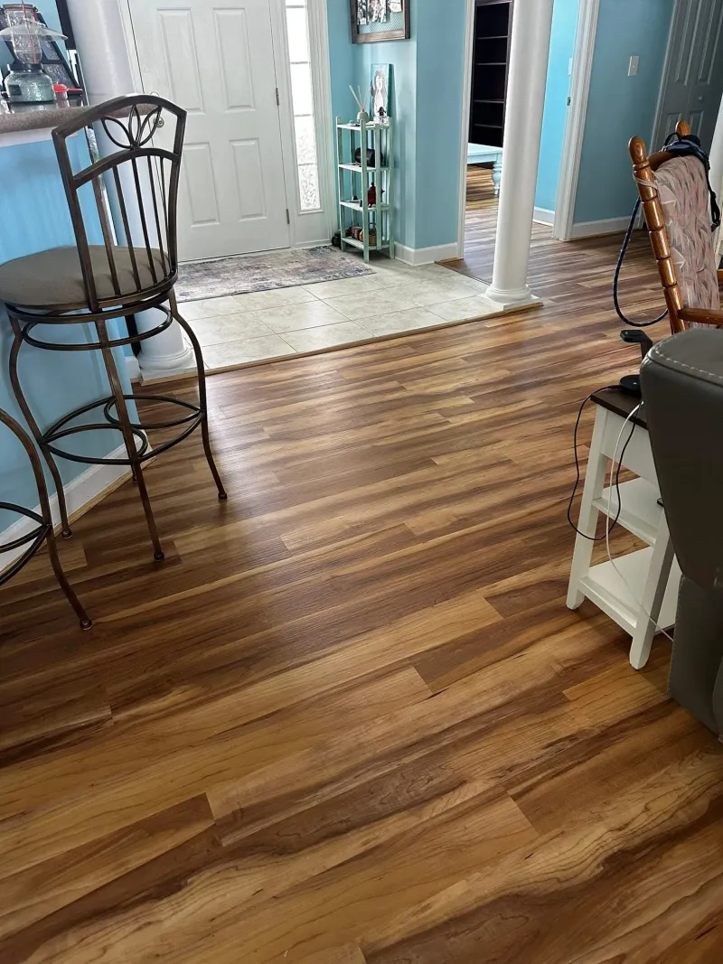 Warm wood-look flooring installed through an open interior space